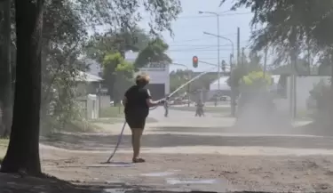 mujer riega la calle